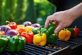 hands placing bell peppers on a gas grill