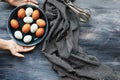 Hands placing a bowl of fresh eggs onto a table