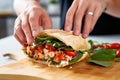 hands placing freshly cooked lobster into a roll