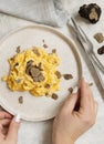 Hands with plate with Scrambled eggs with fresh black truffles top view, gourmet breakfast
