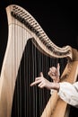 Hands playing wooden harp on black background Royalty Free Stock Photo