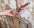 Hands plumber with an adjustable wrench, nut unscrewed flowing t Royalty Free Stock Photo