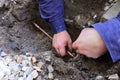 Hands of a plumber fixing an underground water pipe leaking Royalty Free Stock Photo