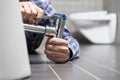 Hands plumber at work in a bathroom, plumbing repair service, as Royalty Free Stock Photo