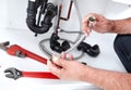 Hands of Plumber with a wrench. Royalty Free Stock Photo