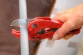 Hands plumbing with a cutter for plastic pipes. Royalty Free Stock Photo