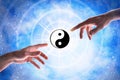 Hands pointing taoist symbol with blue universe background