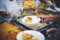 The hands of the poor handed a plate to receive food from volunteers to alleviate hunger, the concept of helping the homeless Royalty Free Stock Photo