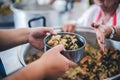 The hands of the poor handed a plate to receive food from volunteers to alleviate hunger, the concept of helping the homeless Royalty Free Stock Photo