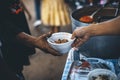 Hands of poor people asking for food from volunteers helping: concept of food donation