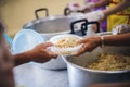 The hands of the poor receive food that volunteers share to alleviate hunger: the concept of donating food to the poor