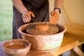 Hands of potte makes pottery dishes on potter`s wheel. Sculptor in workshop makes clay product Royalty Free Stock Photo