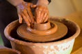 Hands of potte makes pottery dishes on potter`s wheel. Sculptor in workshop makes clay product Royalty Free Stock Photo