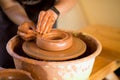 Hands of potter makes pottery dishes on potter wheel. Sculptor in workshop makes clay product Royalty Free Stock Photo