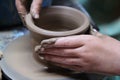 Hands of a potter, creating an earthen jar on pottery wheel. Royalty Free Stock Photo