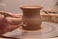 Hands of a potter, creating an earthen jar on pottery wheel. Royalty Free Stock Photo