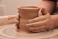 Hands of a potter, creating an earthen jar on pottery wheel. Royalty Free Stock Photo
