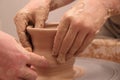 Hands of a potter, creating an earthen jar on pottery wheel. Royalty Free Stock Photo