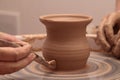 Hands of a potter, creating an earthen jar on pottery wheel. Royalty Free Stock Photo