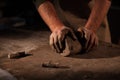 Hands of the potter knead clay.