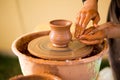 Hands of potter makes pottery dishes on potter wheel. Sculptor in workshop makes clay product Royalty Free Stock Photo