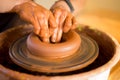 Hands of potter makes pottery dishes on potter wheel. Sculptor in workshop makes clay product Royalty Free Stock Photo