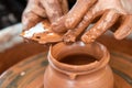 Potter makes pottery dishes on potter`s wheel