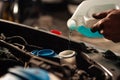 Hands pouring coolant into car radiator, ensuring optimal engine temperature and performance Royalty Free Stock Photo