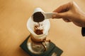 Hands pouring grounded coffee in filter pour over on glass kettle on scale. Preparing for alternative coffee brewing v60. Person Royalty Free Stock Photo