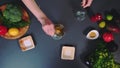 Hands pouring ingredients into a bowl.