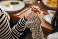 Hands, pray and family at a table for food, blessing and gratitude before sharing a meal in their home together. Hand