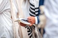 Hands and prayer book close-up. Orthodox hassidic Jews pray in a holiday robe and tallith Royalty Free Stock Photo
