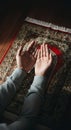 Hands in prayer position on patterned red and beige prayer rug Royalty Free Stock Photo