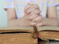 Hands of praying boy going to the first holy communion holding prayer book and wooden rosary concept Royalty Free Stock Photo