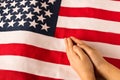 Hands of praying little girl on the background of the American flag. The concept of patriotism Royalty Free Stock Photo