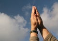 Hands praying to heaven. Sky background. Royalty Free Stock Photo