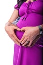 Hands of pregnant couple holding tummy with heart shape hands Royalty Free Stock Photo