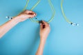 Hands prepare to tune a variable optic attenuator with a screwdriver. Blue background