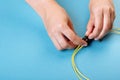 Hands prepare to tune a variable optic attenuator with a screwdriver. Blue background