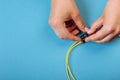 Hands prepare to tune a variable optic attenuator with a screwdriver. Blue background