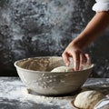 Hands preparing dough closeup, dough in a bowl on rustic kitchen table, hands making pizza, bread Royalty Free Stock Photo
