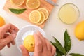 Hands preparing a lemonade squeezing a lemon on bench top Royalty Free Stock Photo
