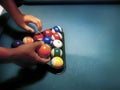 Hands preparing pool balls in triangle rack on the billiard table Royalty Free Stock Photo