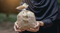 Hands Present a Money Bag for Zakat, Embodying the Islamic Commitment to Help the Poor Royalty Free Stock Photo