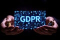 Hands presenting glowing GDPR compliance digital panel binary code symbolizing encrypted online security personal data