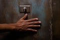 hands pressing the button of a wall-mounted drinking fountain