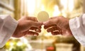 Hands of a priest consecrating a host in the church