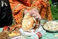 Hands of priest cutting decorated bread