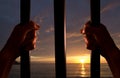 Hands of the prisoner with the sunset in the background Royalty Free Stock Photo