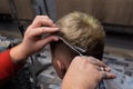 The hands of a professional male hairdresser with scissors and a comb cut the hair of a salon client at work Royalty Free Stock Photo